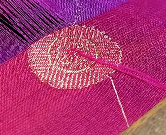 A zari butti woven into magenta silk
